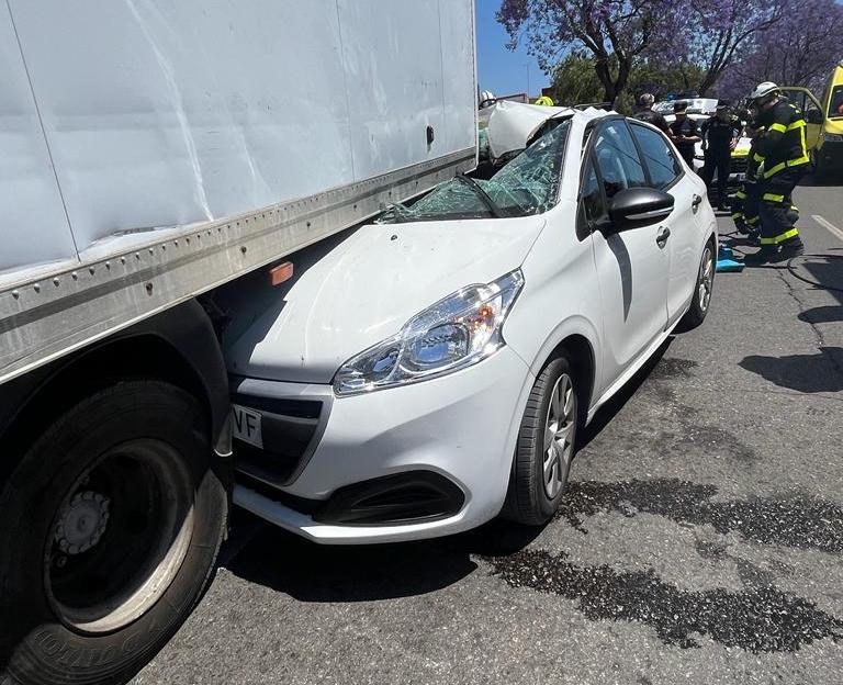 Bomberos de Jerez rescatan a una conductora tras chocar su vehículo y quedar atrapado bajo un camión